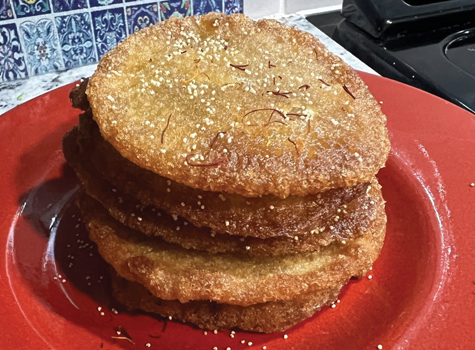 A red plate with three cookies stacked on top of each other.