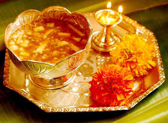 A bowl of soup on a tray with candles.